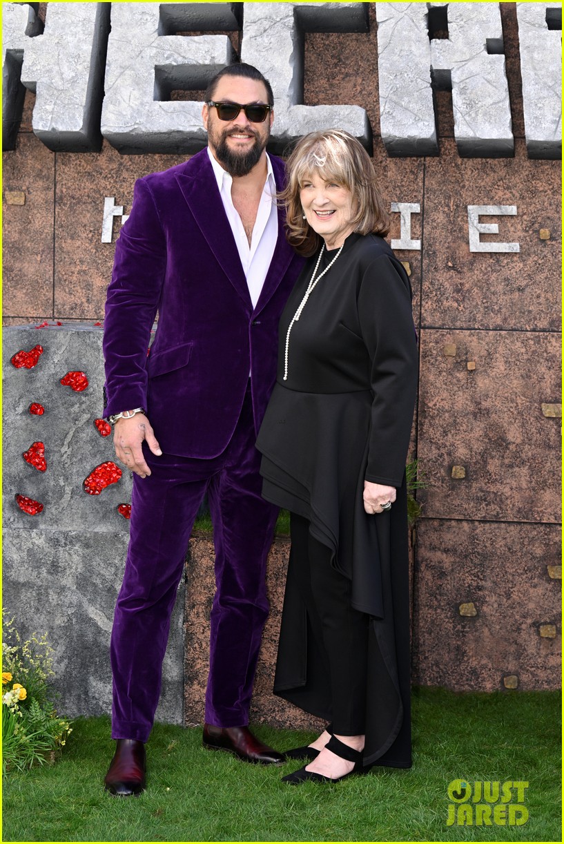 adria arjona purple dress Jason Momoa and Adria Arjona Coordinate in Purple Looks. They were stunning together! Jason seemed to enjoy Adria's silky lavender dress with frilly sleeves and a plunging neckline adorned with ribbon-like details